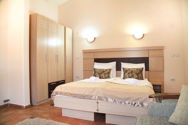 Een slaapkamer met een bed, een houten garderobe en wandlampen.