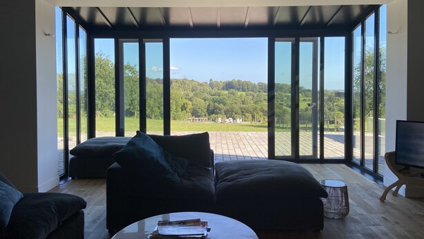 A modern living room with a large window, a sofa, a coffee table, and a television. - Villa l'Etable, 4 bedrooms (Trouville-sur-Mer)
