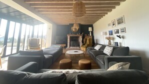 A spacious living room with a high ceiling, large windows, a fireplace, and a cozy seating area. - Villa l'Etable, 4 bedrooms (Trouville-sur-Mer)