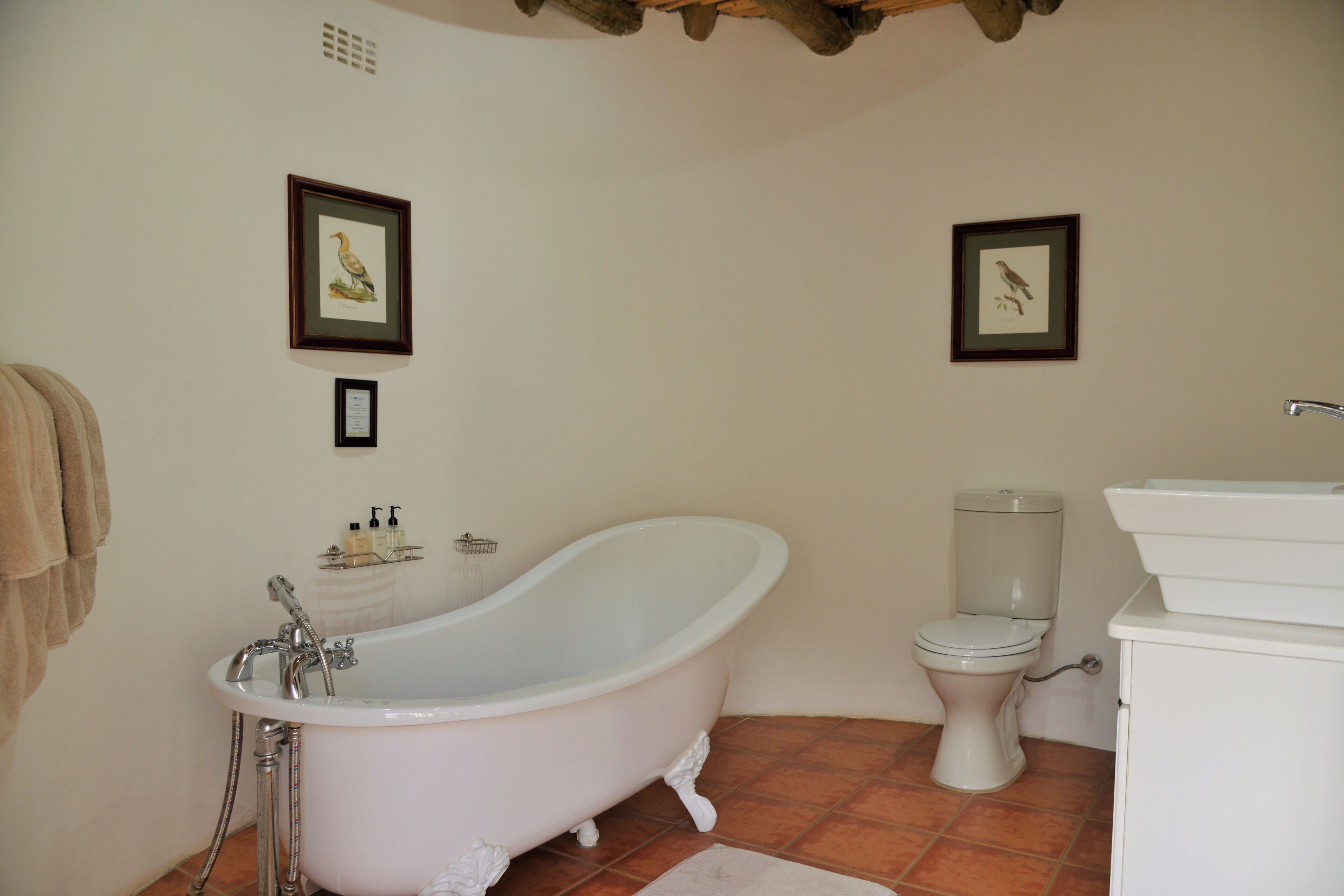 A bathroom with a freestanding bathtub, a toilet, and a sink.