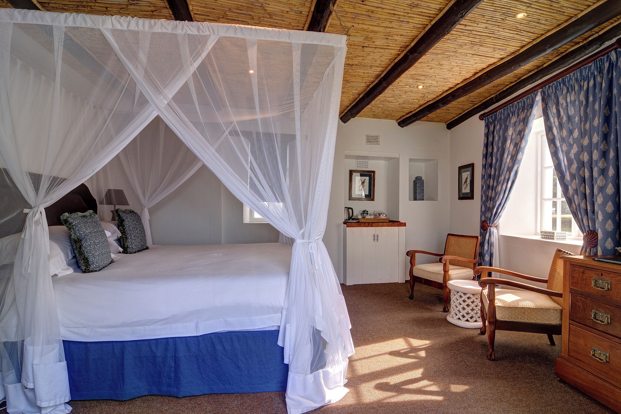 A bedroom with a canopy bed, a desk, and a chair.