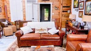A cozy room with a brown leather sofa, a wooden coffee table, and a wooden cabinet.