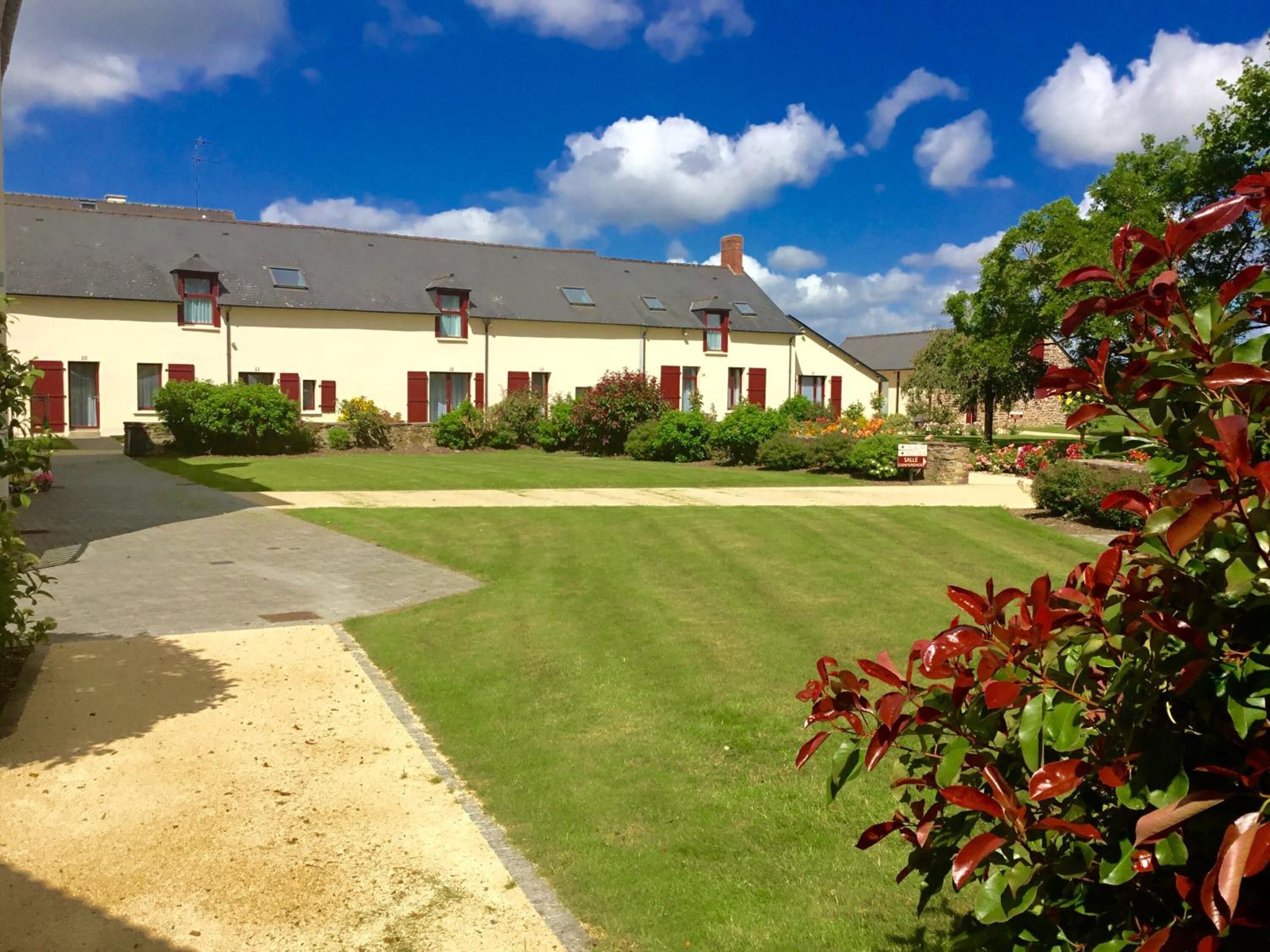 A two-story building with a paved driveway and a well-maintained lawn.