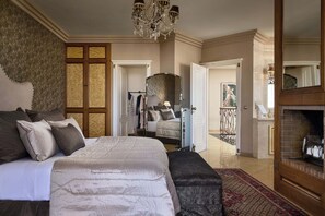 A bedroom with a large bed, a chandelier, a wardrobe, and a fireplace. - Marilyn Manor, Exclusive Hideaway with Private Pool & Close to the Beach (Gouves)