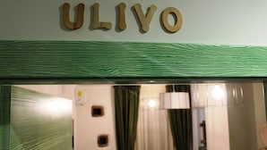 A wooden sign with the name "ULIVO" above a patterned green and white surface, likely part of a hotel or establishment. - Casa Mazzone BB Experience (Ciro)