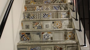 A staircase with patterned tiles and a metal handrail. - Casa Mazzone BB Experience (Ciro)