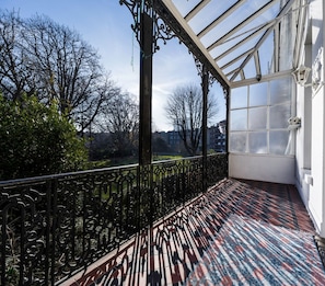 Enjoy the view from this balcony with a geometric-patterned floor and a large window offering a glimpse of the surrounding area.