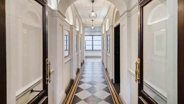 A long, narrow hallway with a checkered floor, white walls, and arched ceilings. - Lovely 2 Bed near Covent Garden & Tube (London)