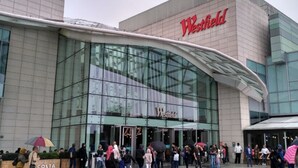 A Westfield shopping mall with a modern glass facade and a curved entrance canopy.