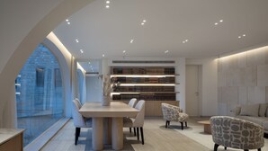A modern dining area with a large table, chairs, and a bookshelf. - Western Wall View Apartment (Jerusalem)