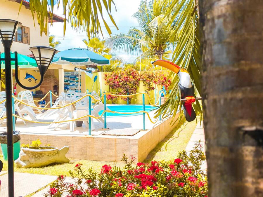 A pool area with lounge chairs, umbrellas, and a rope barrier.