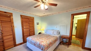 A bedroom with a bed, wooden wardrobes, a ceiling fan, a nightstand, and a lamp. - Wonderful Quiet neighborhood retreat in the Village of Watkins Glen (Watkins Glen)
