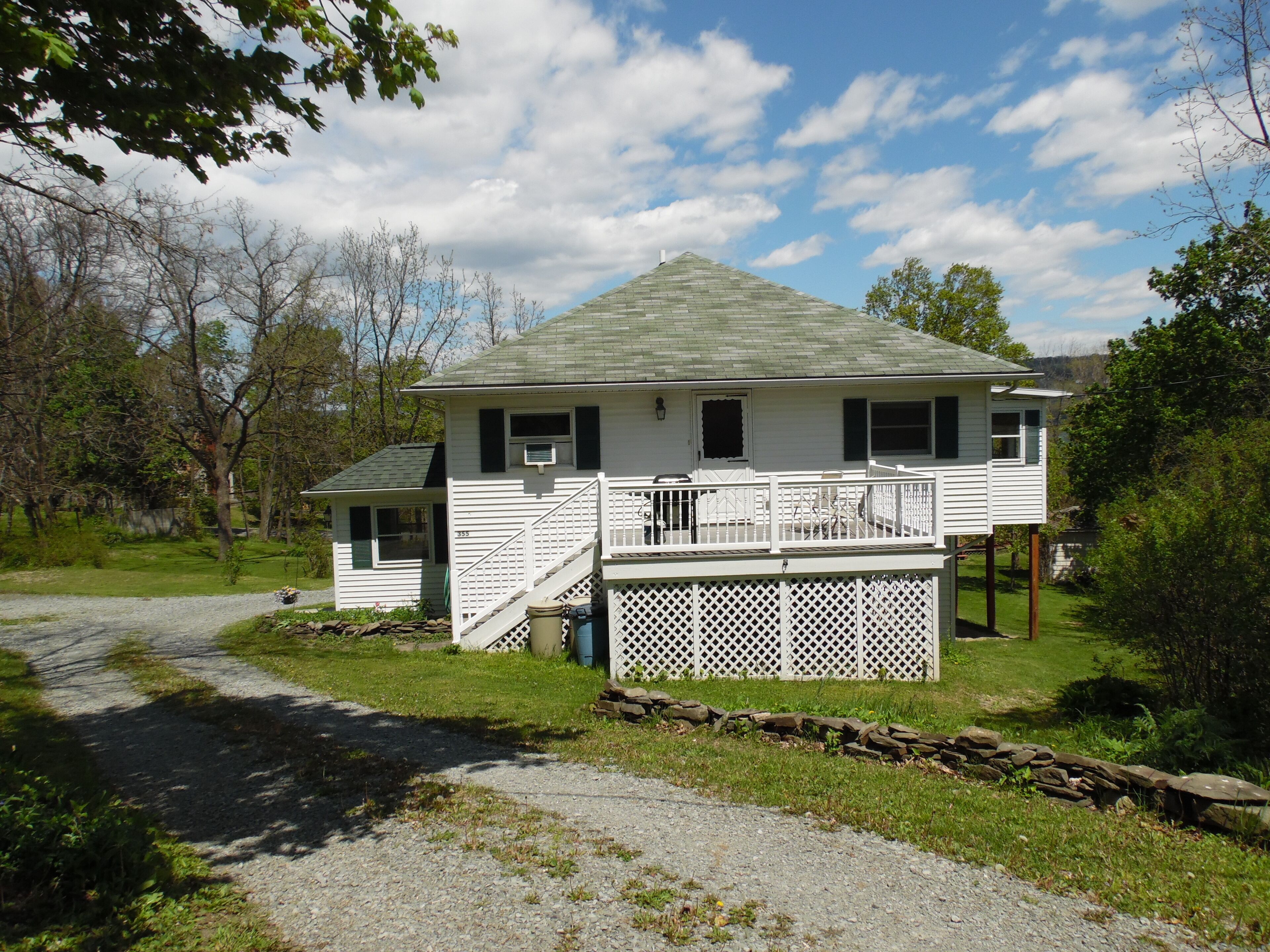 A two-story house with a porch and a small attached shed.