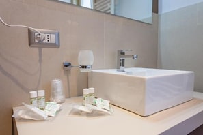 A bathroom with a white sink, a mirror, and a towel rack. There are toiletries on the counter. - Five Rooms Brolo (Brolo)