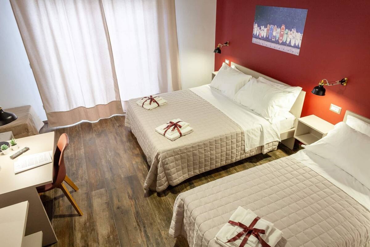 Ein Hotelzimmer mit zwei Betten, einem Schreibtisch und einem Stuhl.