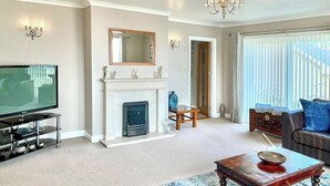 A living room with a fireplace, television, and seating area. - 3 bedroom accommodation in Aberdaron (Aberdaron)