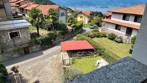 Zona residencial con casas, una calle pavimentada y vistas a montañas distantes y un lago.