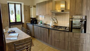Una cocina moderna con armarios de madera, estufa a gas y horno empotrado.