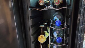 A wine refrigerator with bottles of Altmiihlialter Hell and Sontino Sangiovese.
