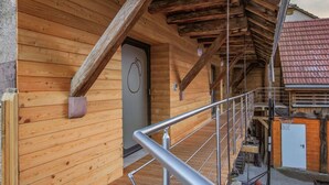 Una cabaña de madera con una escalera de metal y un aro de baloncesto.
