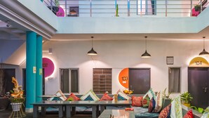 Un área de estar moderna con diversas opciones de asientos, incluyendo sofás y mesas, dispuestas alrededor de una mesa central para café.