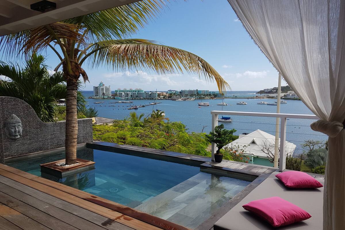 A pool with a view of a marina and buildings.
