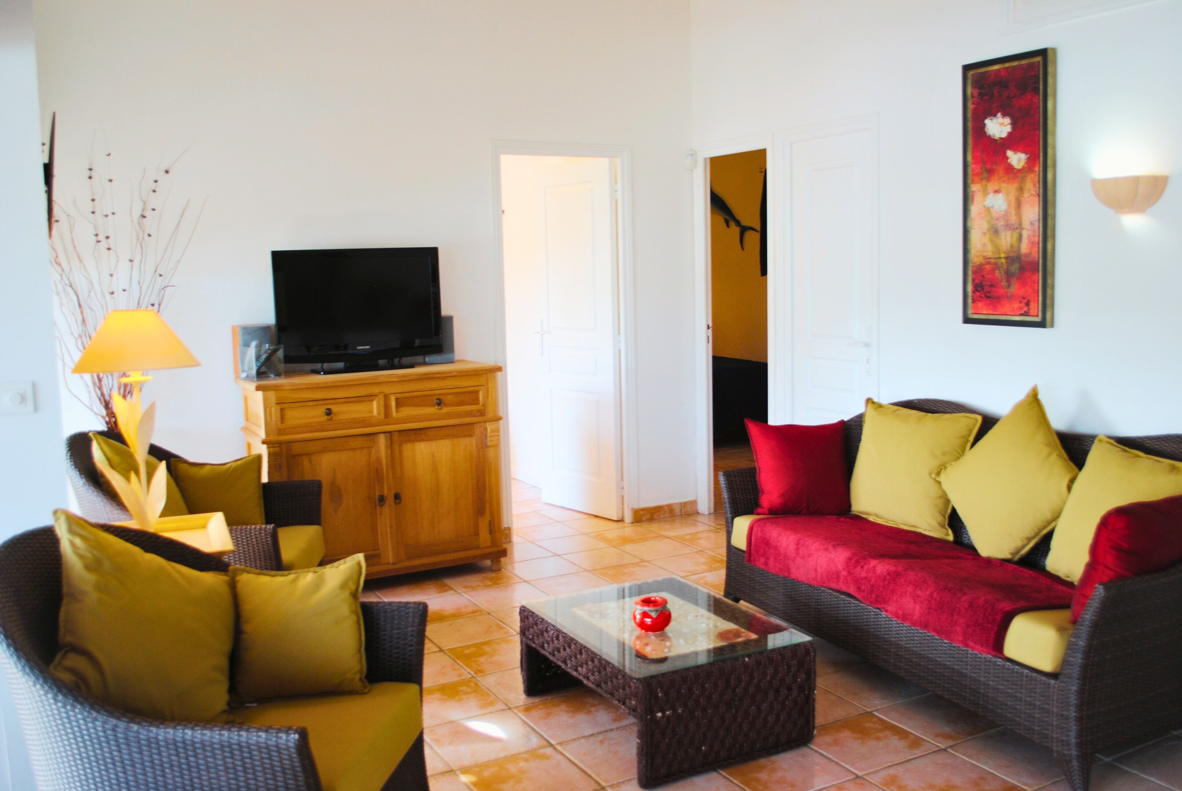 Un salon comprenant un canapé, une table basse, un téléviseur, un meuble et une lampe.