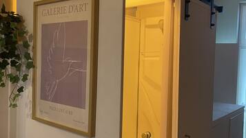 A room with a framed artwork titled 'GALERIE D'ART' and a sliding door leading to a shower area.