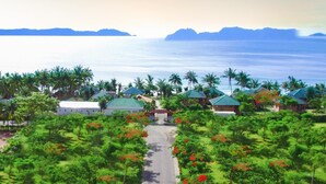 A resort with multiple bungalow-style buildings, a central road, and lush greenery. - TTC Resort - Doc Let (Ninh Hoa)
