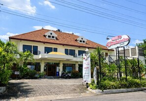 A hotel with a tiled roof, a covered entrance, and a sign indicating a 20% off promotion.