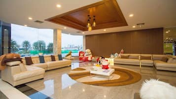A modern living room with a large window, a sofa set, a coffee table, and a decorative rug.