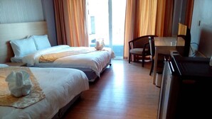 A hotel room with two beds, a desk, and a chair. - CBD 2 Hotel (Surat Thani)