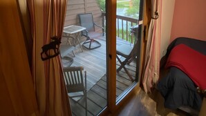 A room with a sliding glass door leading to an outdoor deck with a table and chairs.