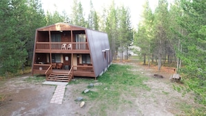 Relax on the spacious deck with seating, surrounded by a serene natural forest setting.