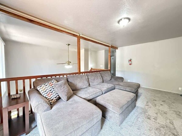 Una sala de estar con un sofá modular, un banco de madera y una mesita.