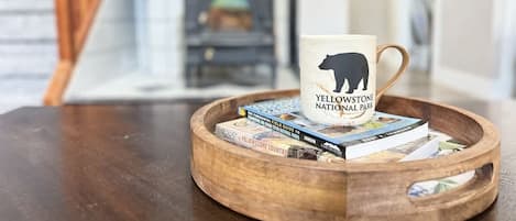 Een houten dienblad met een mok waarop 'Yellowstone National Park' staat en er boeken op liggen.