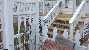 A white house with a porch, a wooden fence, and a wooden bench. -  Bloomin Pickets Farmhouse Stay OR Ladies Craft Retreat! (Monroe)