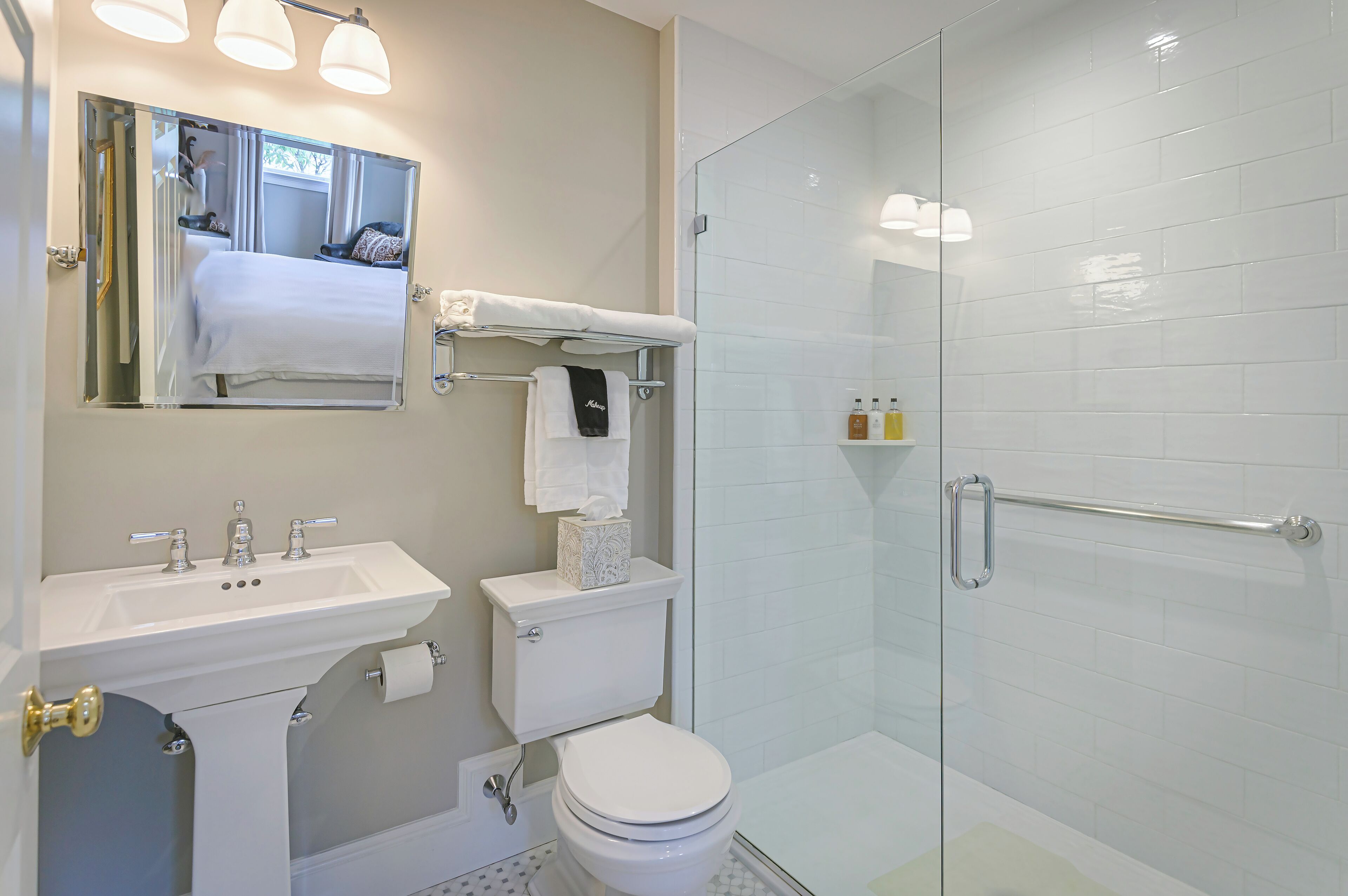 Een moderne badkamer met een wastafel, toilet en douchecabine met glazen wanden.