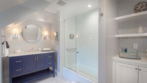 A modern bathroom with a glass-enclosed shower, a vanity with a mirror, and a white cabinet. - The West Lane Inn - Double Queen Room (Ridgefield)