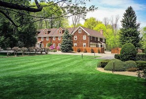 A large brick house with a well-maintained lawn and a Christmas tree. - The West Lane Inn - King Studio Suite with kitchenette (Ridgefield)