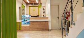A reception area with a counter, a glass display case, and a fire extinguisher. - Sun City (New Delhi)