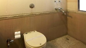 A small bathroom with a toilet, a hand dryer, and a paper towel dispenser. - Sun City (New Delhi)
