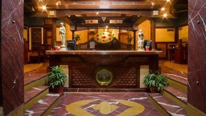 A lobby with a marble floor, a reception desk, and two potted plants. - Sunstar Grand (New Delhi)