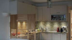 Una cocina moderna con armarios de madera, encimera de mármol y horno empotrado.