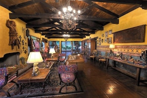 A cozy interior with wooden beams, a chandelier, and a fireplace. - Atitlan (Sololá)