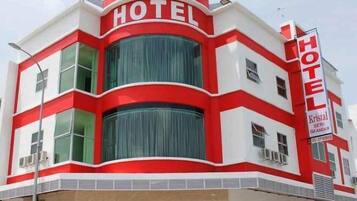 A hotel with a distinctive red and white facade, large windows, and a prominent sign.