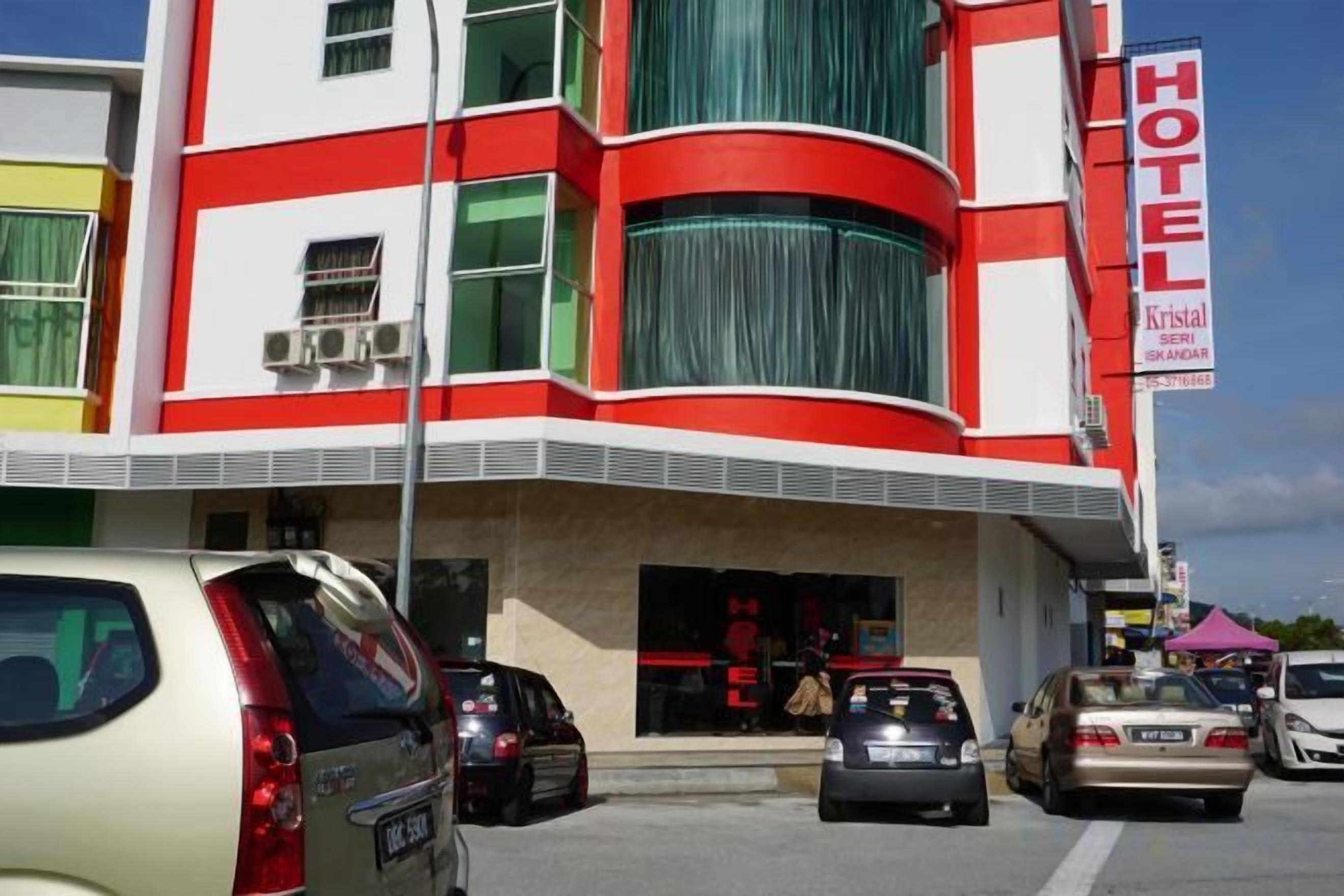 Un bâtiment d’hôtel à la façade rouge et blanche, doté de nombreuses fenêtres et d’une entrée bien visible.