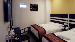 A hotel room with two beds, a desk with a chair, a television, and a small window. - HOTEL KRISTAL SERI ISKANDAR (Bota)