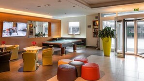 A modern lounge area with a pool table, comfortable seating, and a large plant. - Bes Hotel Bergamo West (Mozzo)