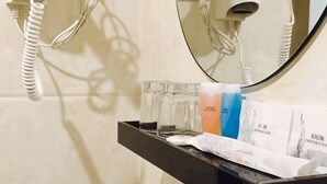 A bathroom with a mirror, a hairdryer, and toiletries on a shelf. - K GARDEN HOTEL PARIT BUNTAR (Parit Buntar)
